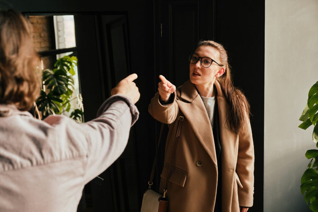 a ADHD woman pointing at a woman in a coat